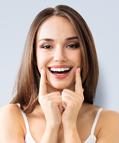 Woman showing off smile after crown lengthening and recontouring