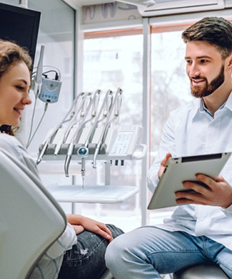 A dentist shows a female patient her dental x-rays while explaining the treatment that will be covered by her dental insurance in Mayfield Heights