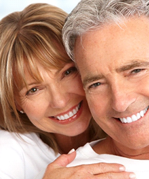 An older couple hugging and smiling after receiving exceptional periodontal care in Mayfield Heights