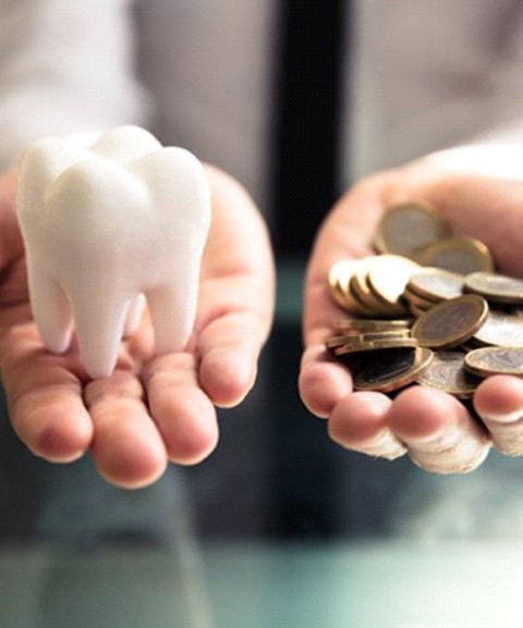 Tooth and a pile of coins being held