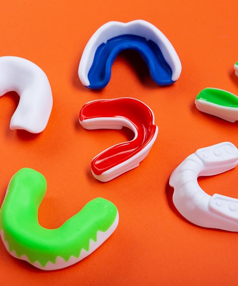 Colorful mouthguards used for sports against orange background