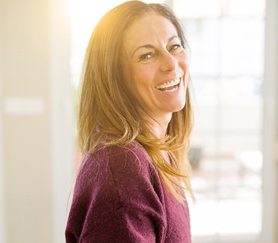 woman smiling and enjoying the health benefits of dental implants in Mayfield Heights