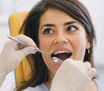 Woman preparing for tooth extraction in Mayfield Heights for dental implants