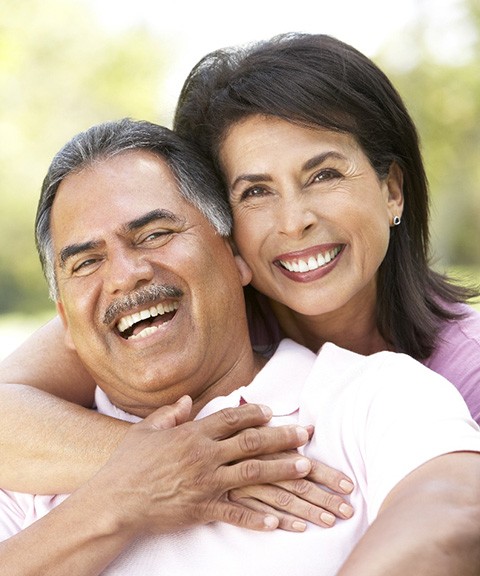 Smiling couple with dental implants in Mayfield Heights