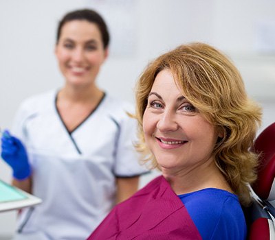 Woman smiling during checkup with Mayfield Heights implant dentist