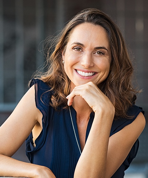 Woman smiling after laser assisted peri implantitis treatment