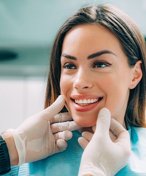 Periodontist examining patient's smile after periodontal therapy