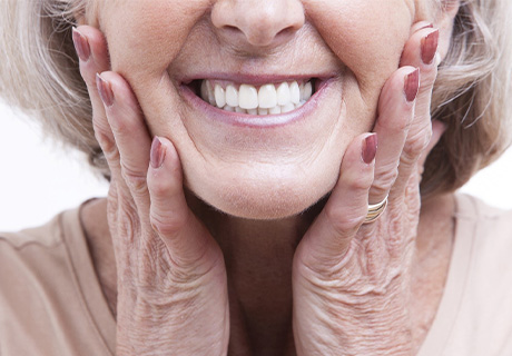 Woman showing offer her new dental implants in Mayfield Heights 