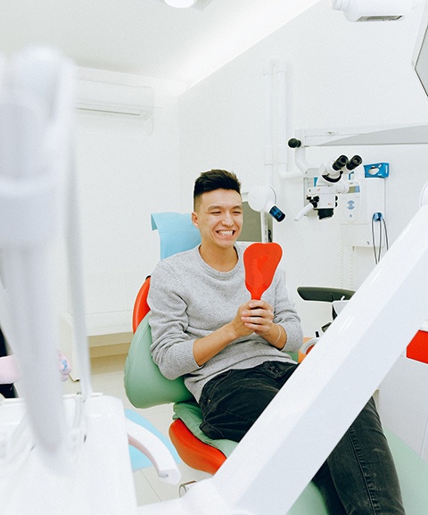 Man in dental chair looking in mirror