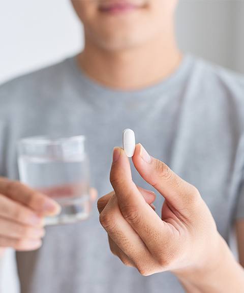 Patient holding up oral conscious sedation dentistry pill