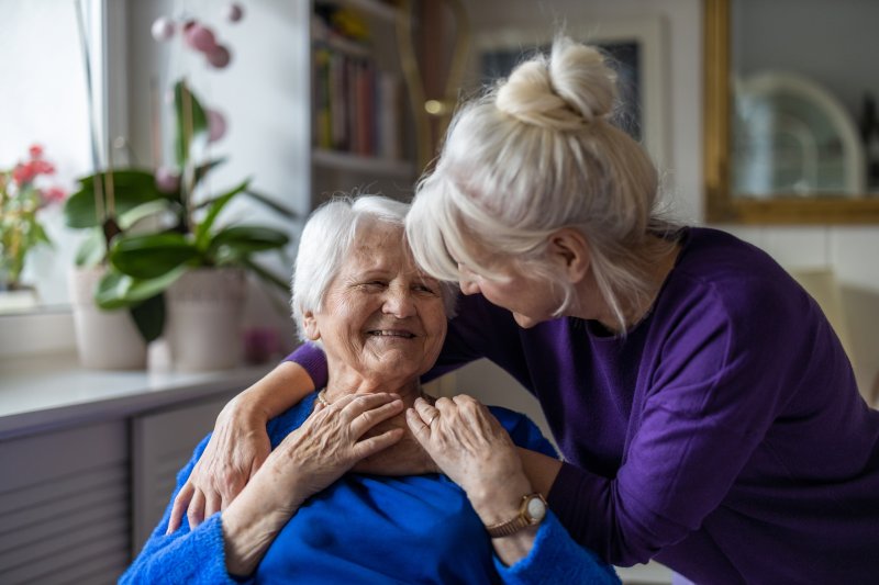 a patient with Alzheimer’s disease smiling at their caretaker