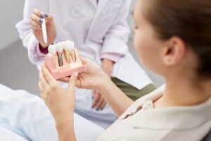 Dentist showing patient dental implant. 